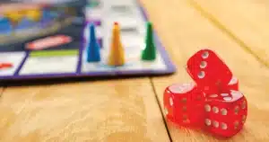 Board Game in back ground with 4 dice in right corner